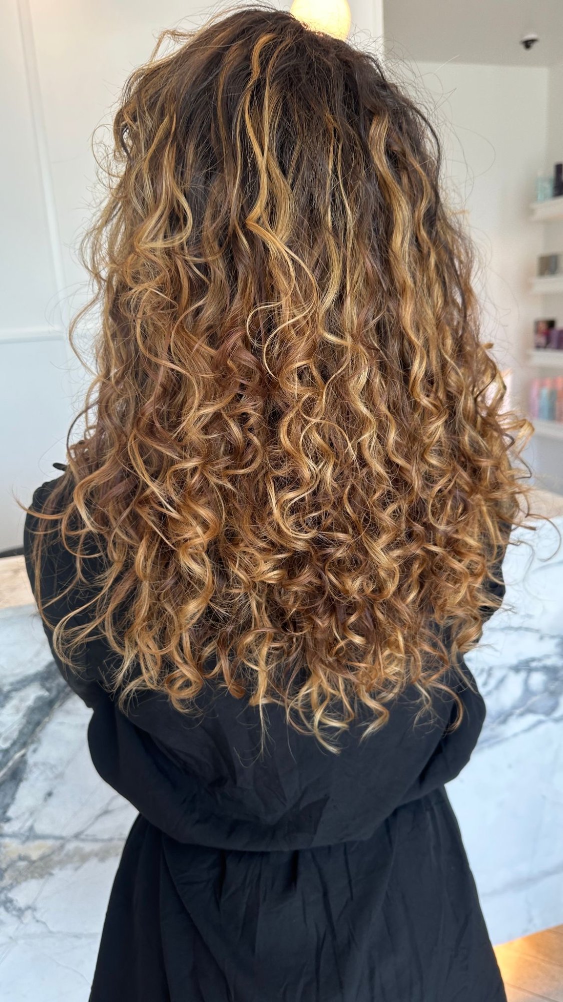 Voluminous curly hair blowout styling result