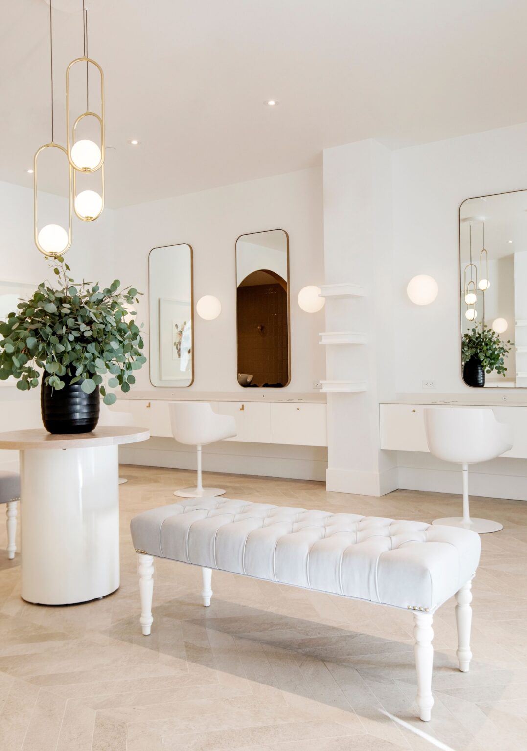 Wish Dry Bar West Vancouver salon interior with white tufted bench and gold chandeliers